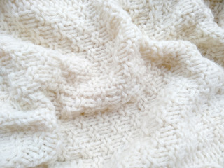 Fototapeta na wymiar Background of wool yarn for yarn frame. White knitting yarn for handicrafts background. Knitted clothes from wool yarn.