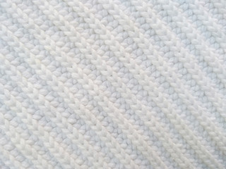 Background of wool yarn for yarn frame. White knitting yarn for handicrafts background. Knitted clothes from wool yarn.