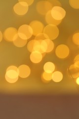 Golden bokeh festive background. Shiny glitter brown gold pattern. Shining background in warm colors. IPhone wallpaper.