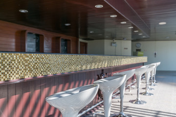 Modern bar counter with empty white chairs in the morning