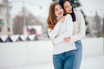 Cute girl standing in a winter city. Woman in a white sweater.