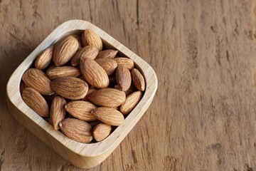 Almond nut in wood bowl on wooden table background