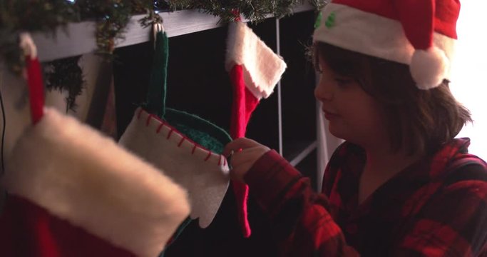 Young boy feels through stockings for presents on Christmas, finds coal in the last one - slow motion - shot on RED
