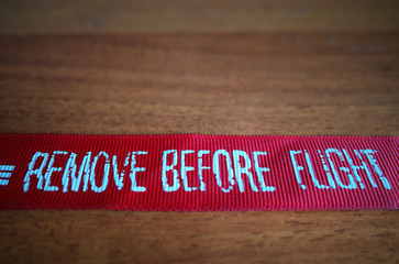 "Remove before flight" ribbon from pilot jacket background