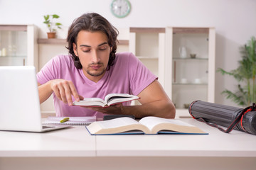 Young male student preparing for exams at home