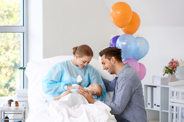 Young family with newborn baby in maternity hospital