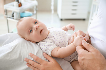 Young parents with newborn baby in maternity hospital, closeup