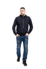 Running handsome young man in jeans. Hands in pockets. Isolated over white background. Vertical.