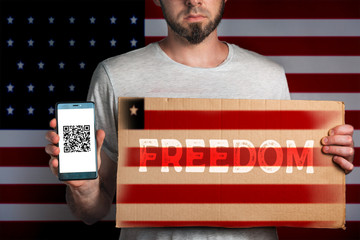 Concept of freedoms and human rights. A man with a cardboard and a phone in his hand. The Flag of...