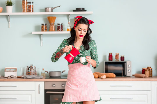 Portrait of beautiful pin-up woman with coffee in kitchen