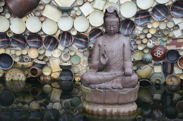 buddha statue and wall of plates