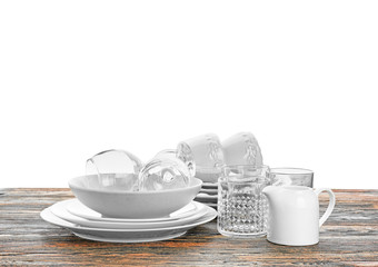 Set of clean dishes on table against white background