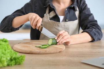 Woman preparing tasty vegetable salad in kitchen