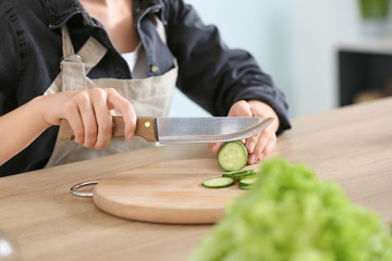 Woman preparing tasty vegetable salad in kitchen
