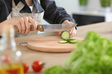 Woman preparing tasty vegetable salad in kitchen