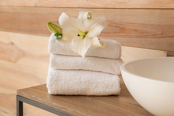 Obraz na płótnie Canvas Clean towels on table near wooden wall