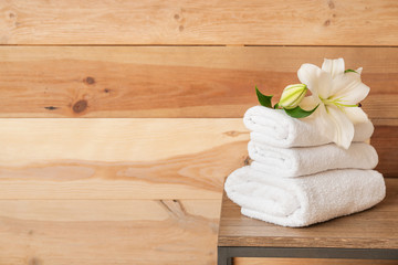 Fototapeta na wymiar Clean towels on table near wooden wall