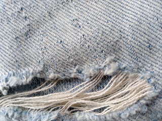 Ripped destroyed jeans background. Jeans torn denim texture. Blue jeans background.