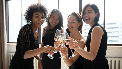 Happy beautiful women hold glasses look at camera celebrate party