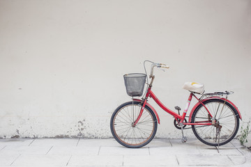 Fototapeta na wymiar red bicycle with basket in front of the white wall, background