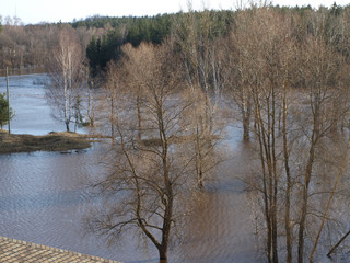 misty spring landscape with flooded river, view from above over the roof