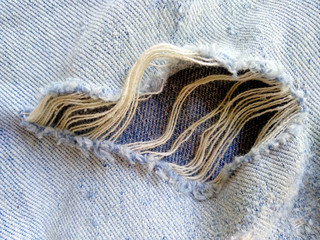 Ripped destroyed jeans background. Jeans torn denim texture. Blue jeans background.