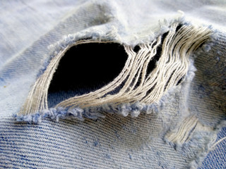 Ripped destroyed jeans background. Jeans torn denim texture. Blue jeans background.