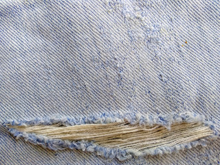 Ripped destroyed jeans background. Jeans torn denim texture. Blue jeans background.
