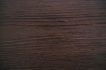 Classic brown wooden background made of dark natural wood in the style of grunge. Top view. Raw planed texture of coniferous pine varnished. The surface of the table for shooting flat lay. Copy space