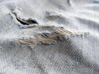 Ripped destroyed jeans background. Jeans torn denim texture. Blue jeans background.