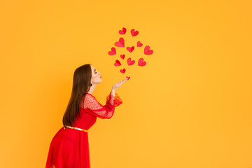 Beautiful young woman with red hearts on color background. Valentine's Day celebration