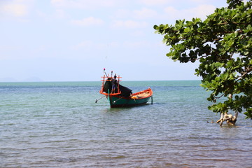 Moored traditional khmer fishing boat in the sunny coast, showing a candid summer moment and daily life in Kep Cambodia 
