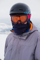 Young snowboarder riding in the mountains on a snowboard.