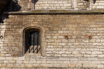 Fototapeta na wymiar Abstract medieval brick wall with barred window