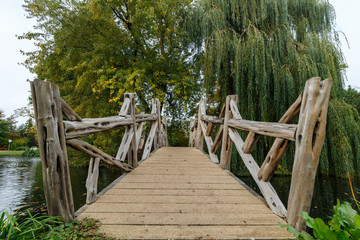 Wooden Bridge Over Water Leading to trees