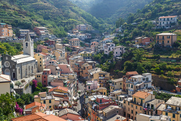 Fototapeta na wymiar RIOMAGGIORE / ITALY - JULY 2015: View to coastal Riomaggiore village in Cinque Terre, Italy