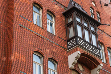 Old brick wall background building with vintage windows and wooden balcony, bottom view