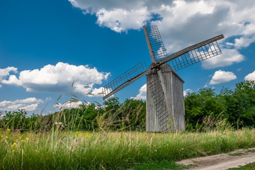 Fototapeta na wymiar Windmill on a wheat field in the sun.