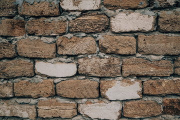 Brown old stone wall close-up of a block of shell rock in grunge style. Vintage texture of the brickwork. Background for the subject flat lay. Concept of construction and interior design. Copy space