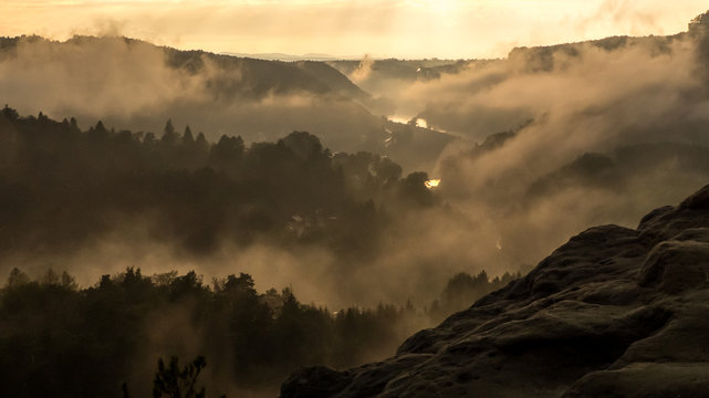 View from Gamrig over the foggy Elbe valley in Saxon Switzerland at sunset