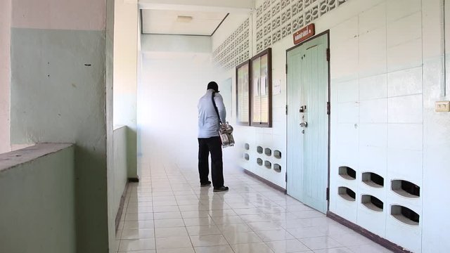 A man use fumigation mosquitoes machine for kill mosquito carrier of Zika virus and dengue fever prevention outbreak in school at the rainy season.Soft and blur focus.