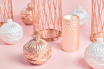 still life of candles in the form of a ball and candlesticks copper color on a pink background. close up