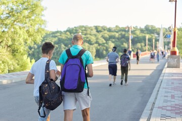 Lifestyle of young males, teenagers with backpacks walking their backs