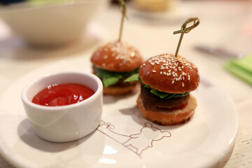 Two mini burgers and ketchup