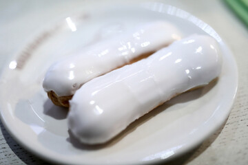 Two vanilla eclairs with icing