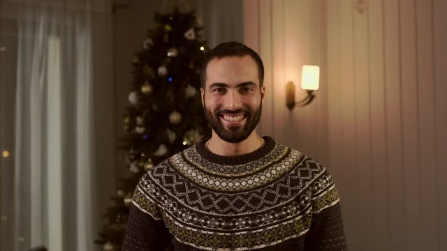 Portrait Of Young Arab On Christmas Tree Background.