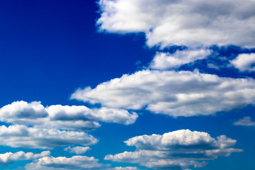 Abstract background of dense white clouds on a saturated blue sky