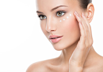 Obraz na płótnie Canvas woman with healthy face applying cosmetic cream under the eyes
