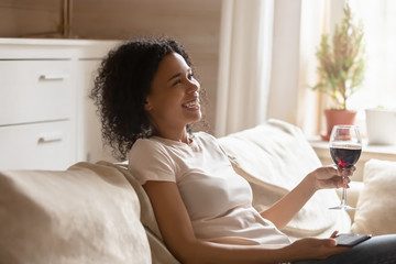 Smiling african American woman relaxing on cozy sofa