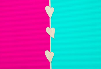 Fototapeta premium Wooden Hearts are on the pink and blue background. Valentine's card. Flatlay. Empty space.